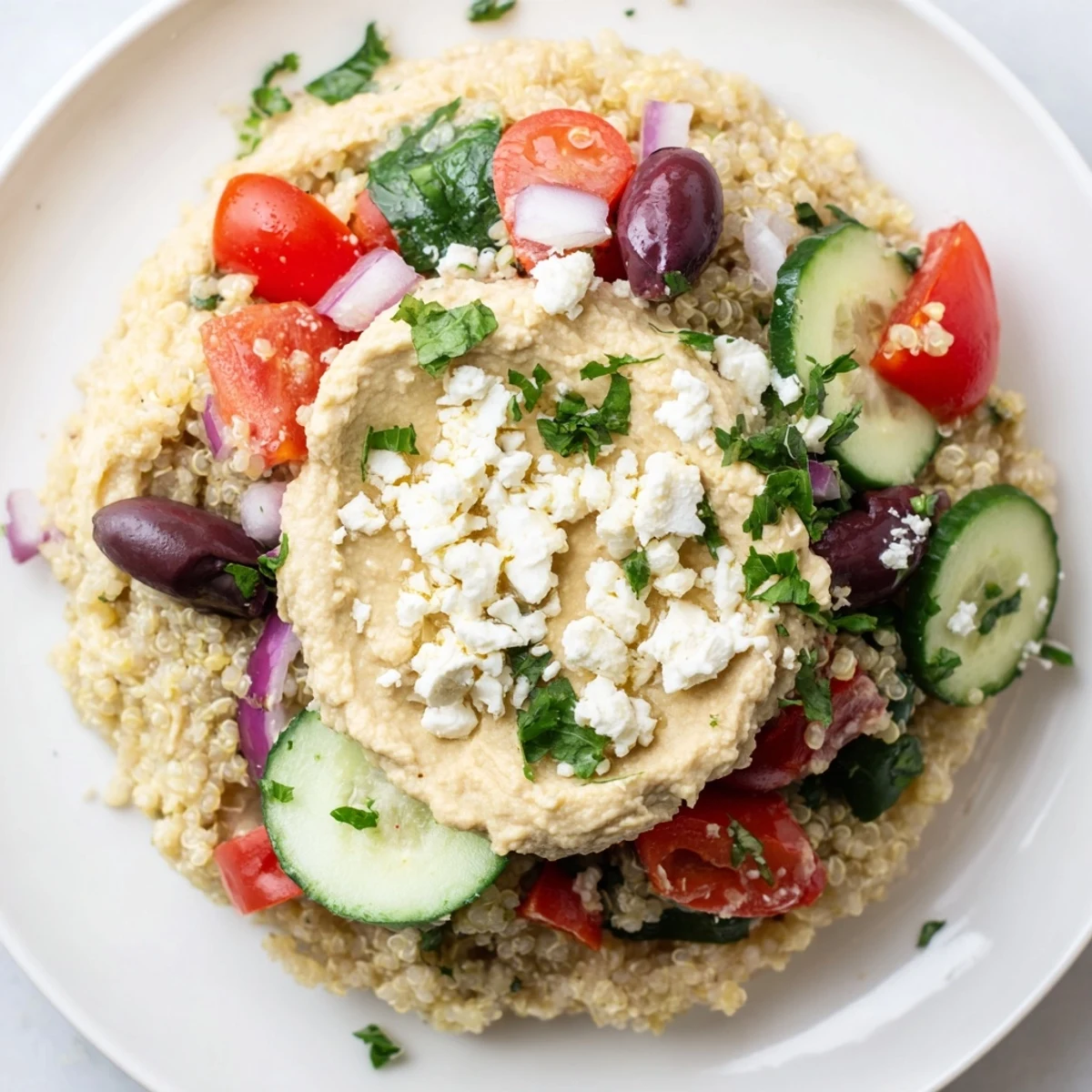 Mediterranean Quinoa Bowl piled high, with colorful veggies and creamy hummus visible.