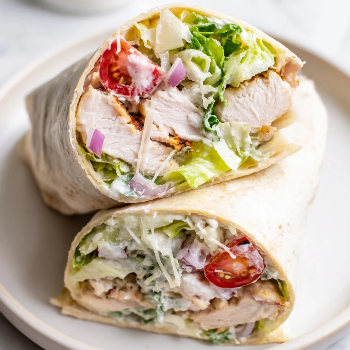 Freshly grilled chicken slices and crisp romaine lettuce bundled in a tortilla for a Chicken Caesar Wrap.