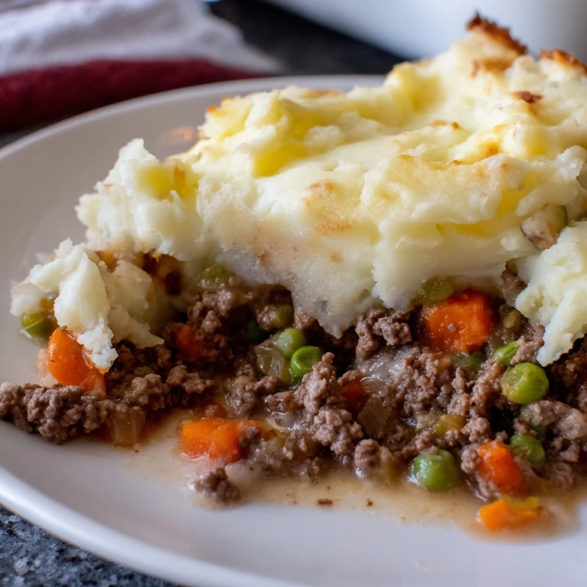 Golden-brown mashed potato topping on a hearty Beef Shepherds Pie with Peas, fresh from the oven.