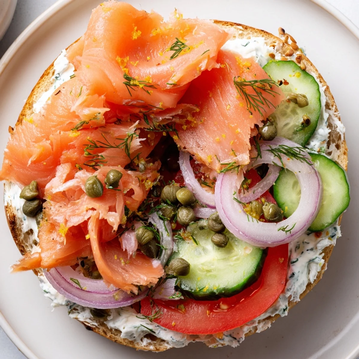 Golden-brown flaked baked salmon and herbed cream cheese piled high on a toasted everything bagel, garnished with red onion and fresh dill.