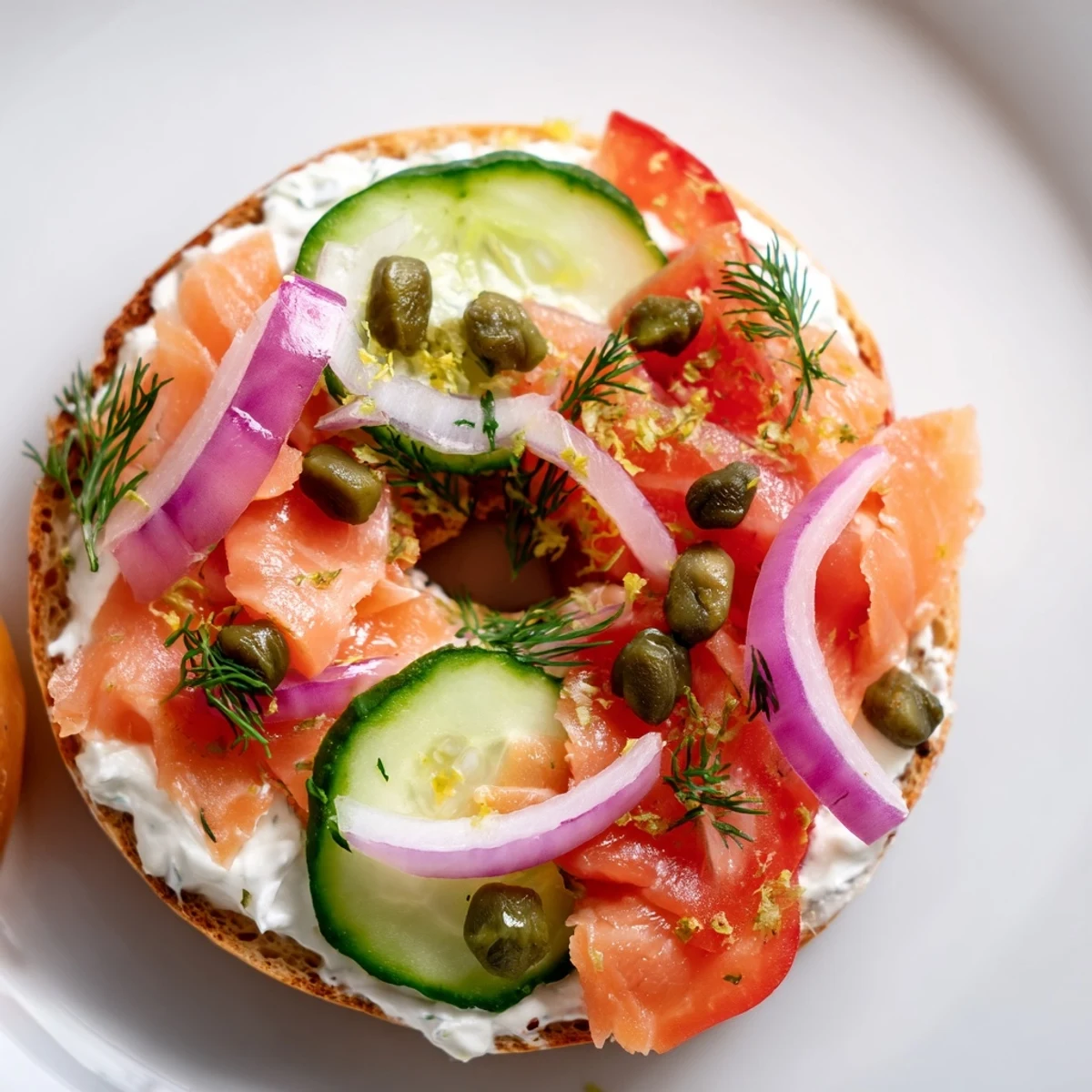 Freshly baked salmon fillets flaked over a toasted bagel with herbed cream cheese, red onions, tomatoes, and capers.