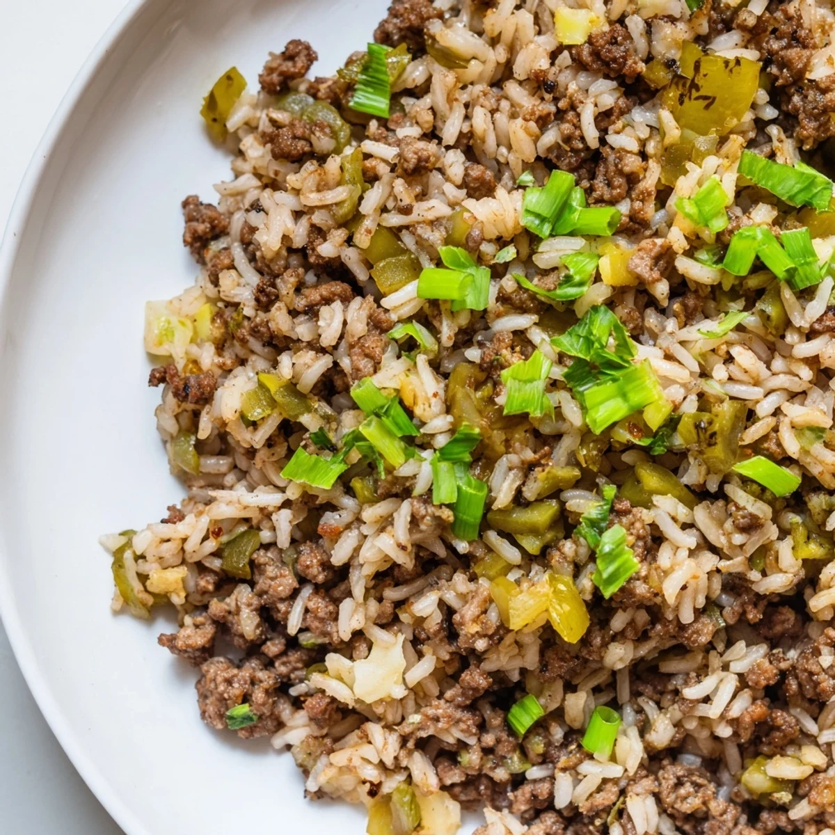 Steaming bowl of Cajun Dirty Rice with Ground Beef, garnished with fresh parsley and green onions.