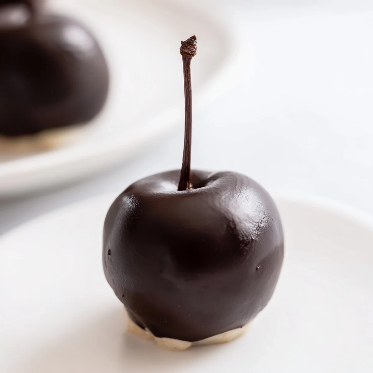 Platter of chocolate covered cherries garnished with cocoa dust and chopped nuts, a perfect gift idea for the holiday season.