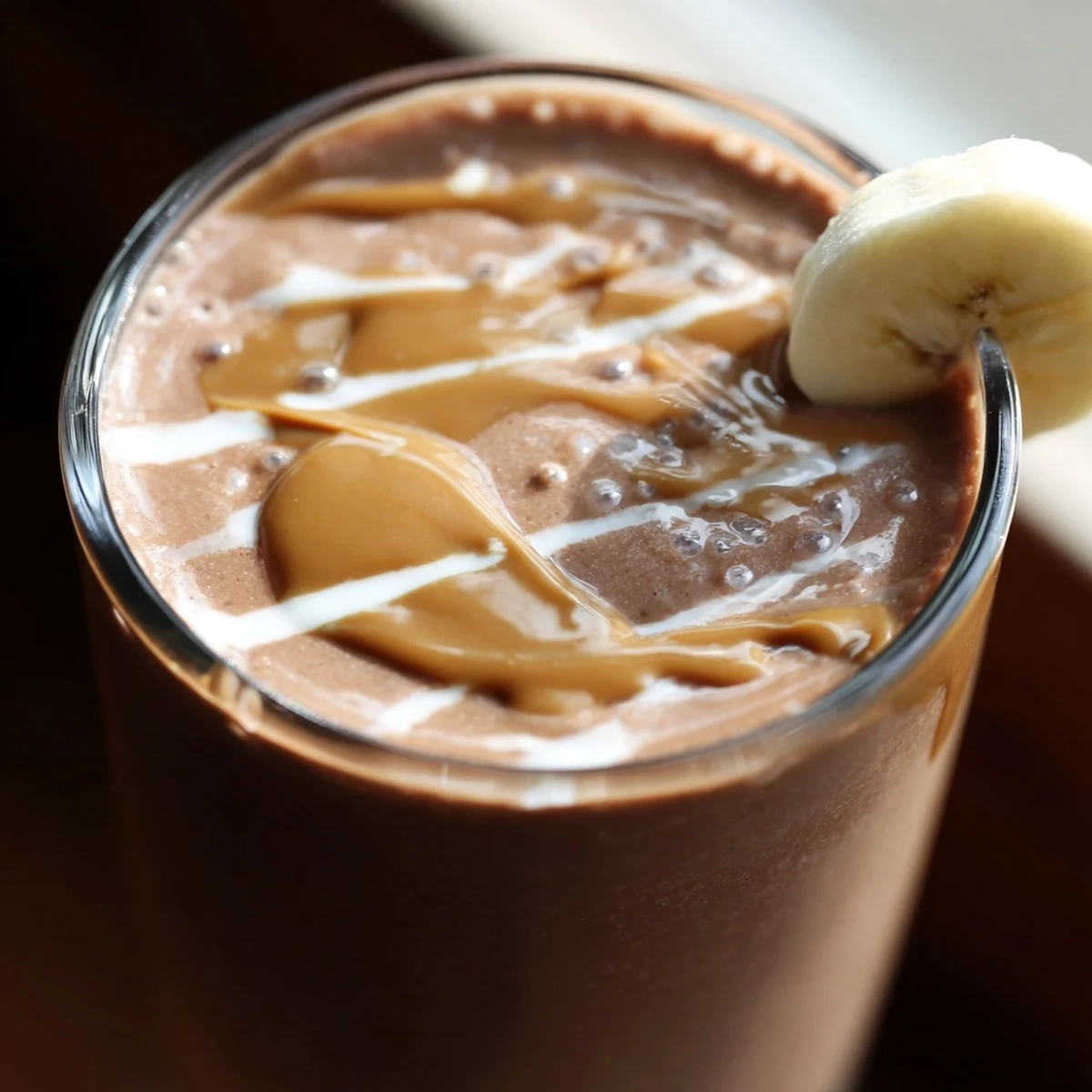 Creamy Chocolate Peanut Butter Smoothie with Banana blended with ice, garnished with crushed peanuts for extra crunch.  