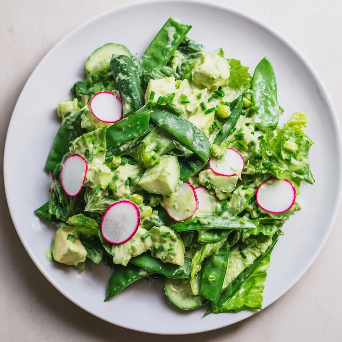 Freshly blended avocado dressing coats this Green Goddess Salad, featuring cucumber, snap peas, and radishes for a crisp, healthy bite.