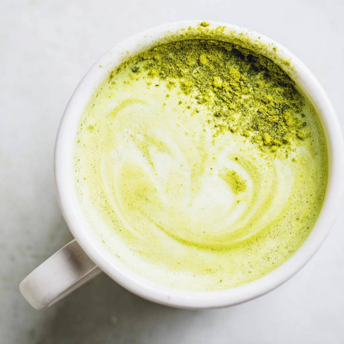 Homemade Green Matcha Latte with Oat Milk and Honey beside honey dipper and whisk, perfect for morning sipping.