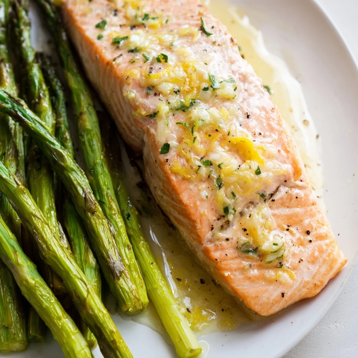 Tender salmon fillets drizzled with lemon garlic butter, paired with crisp roasted asparagus for an elegant dinner.