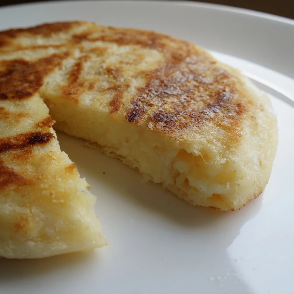 Golden-brown Irish Potato Bread Farls sizzling in a skillet, ready to serve with butter for a hearty breakfast.  