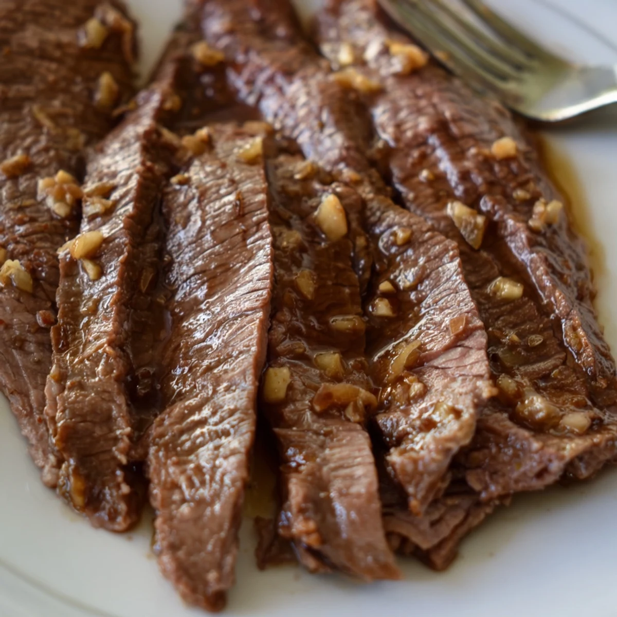 Steaming slices of Ultimate Slow Cooker Mongolian Beef served over jasmine rice with scallions.