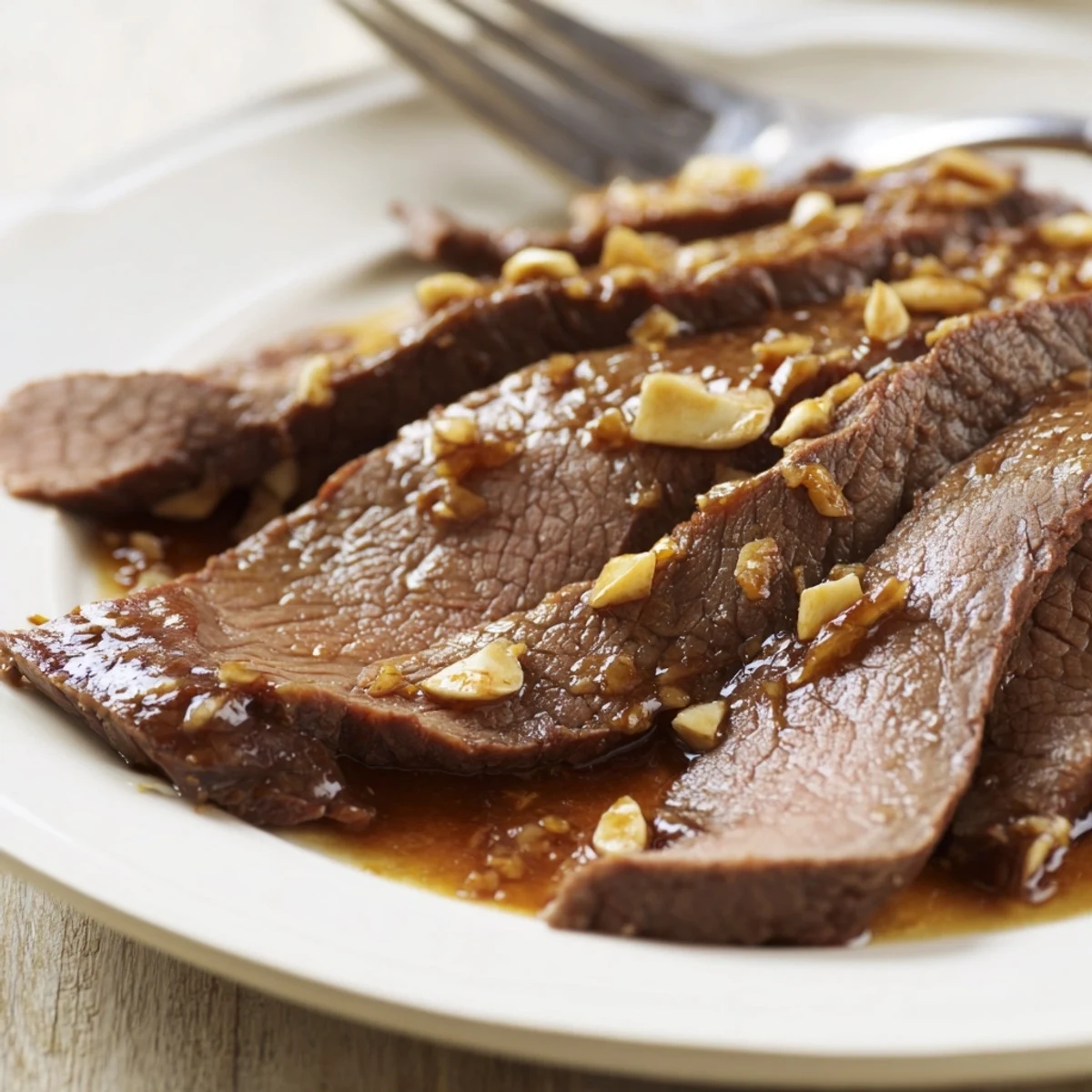 A close view of tender Ultimate Slow Cooker Mongolian Beef with a glossy, savory sauce.