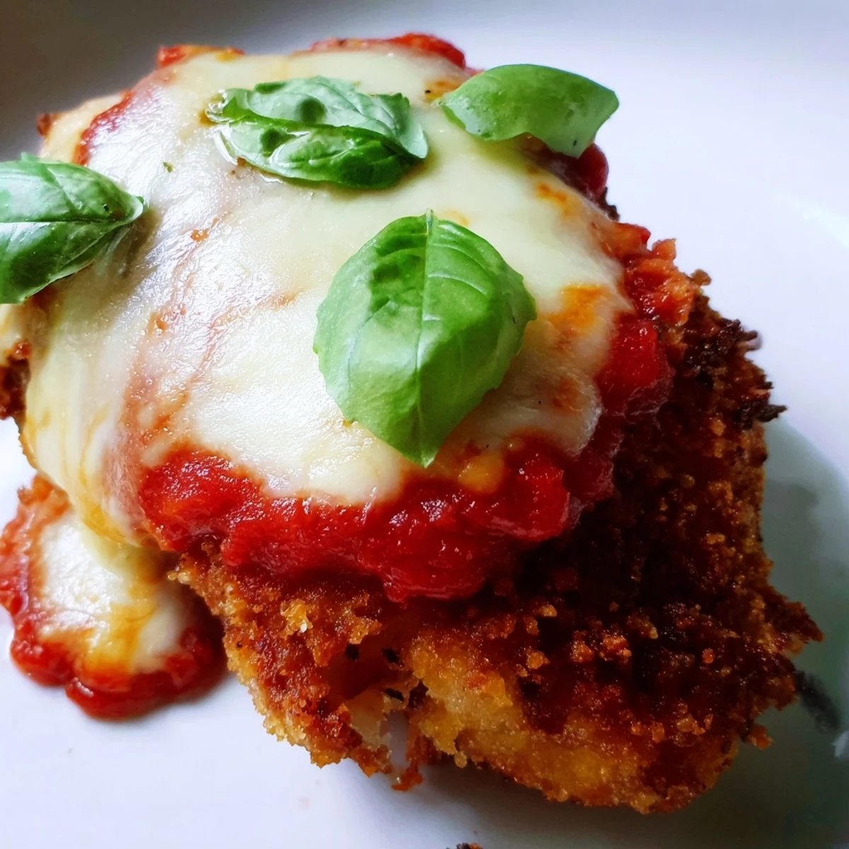 Golden-brown breaded chicken with red marinara and gooey cheese, served hot from the oven as a Chicken Parmesan Pizza.