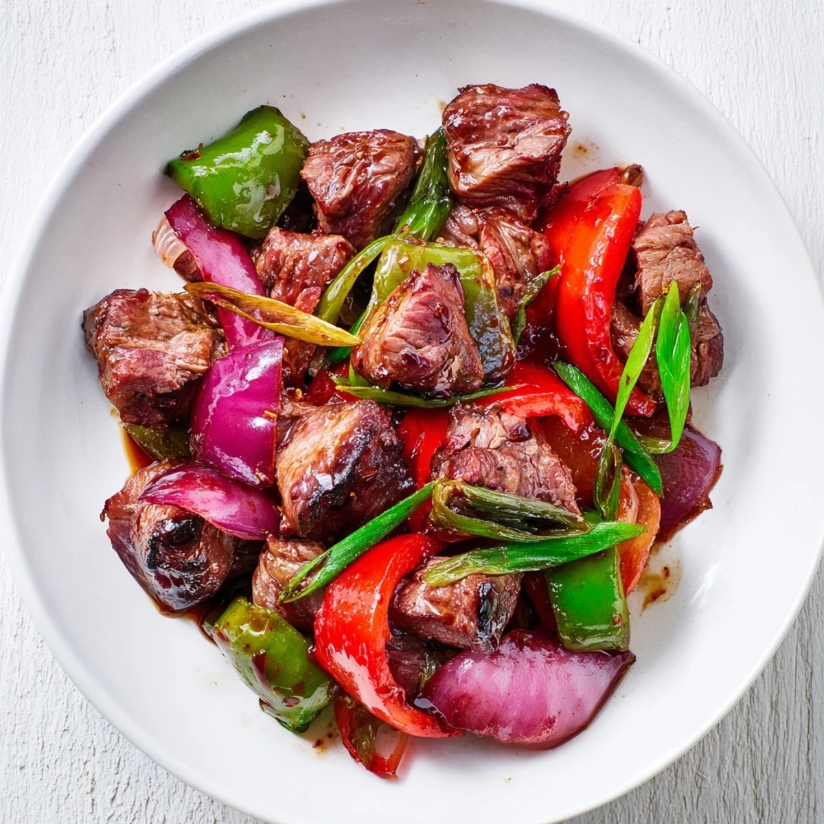 A vibrant platter of Vietnamese Shaking Beef alongside fluffy jasmine rice and fresh herbs.