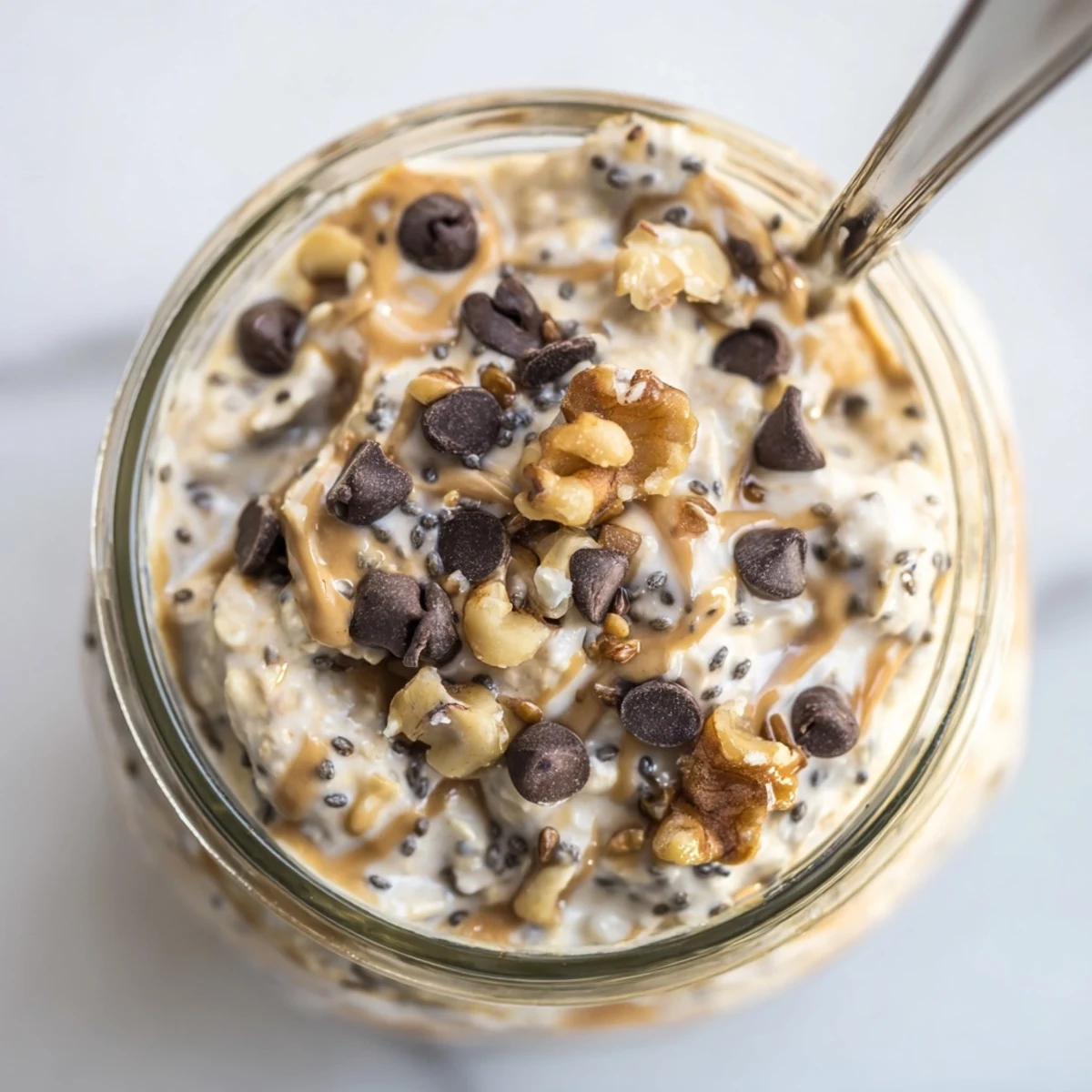 Indulgent Cookie Dough Overnight Oats garnished with sliced bananas and a drizzle of maple syrup on top.