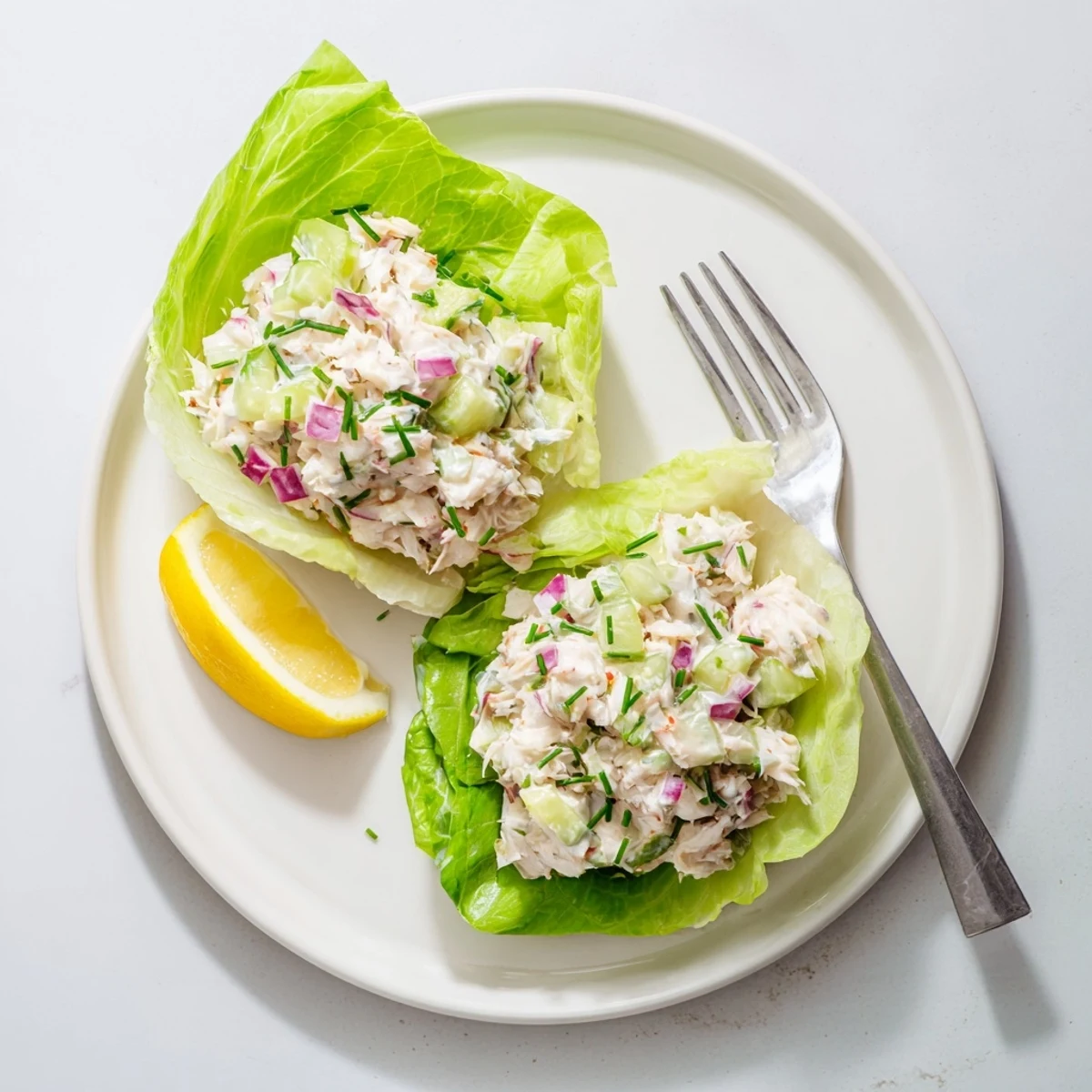 Serving suggestion for a homemade Crab Salad, garnished with fresh chives and parsley on a bed of butter lettuce.