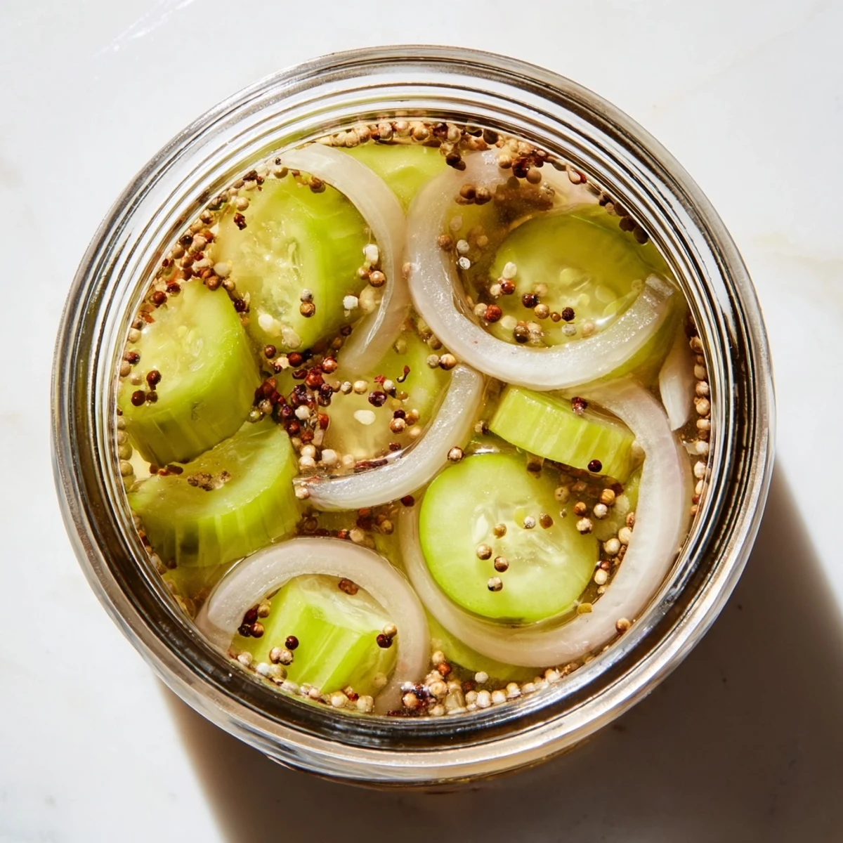 Bright, tangy Quick Pickled Celery in a glass jar, crisp slices glistening in brine with peppercorns and mustard seeds.