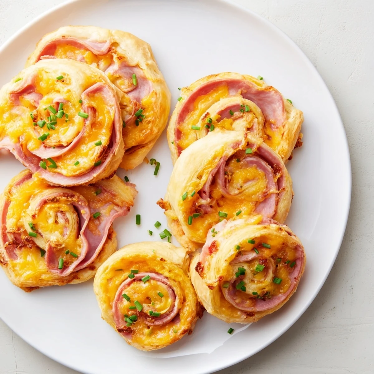 Festive spring appetizer pinwheels featuring puff pastry, ham slices, and herbs