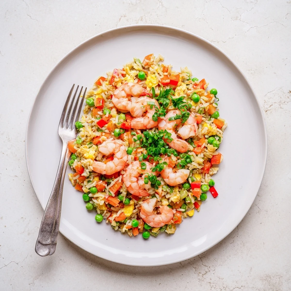 Golden garlic prawns atop colorful sweet chilli fried rice with crisp vegetables and fresh parsley garnish