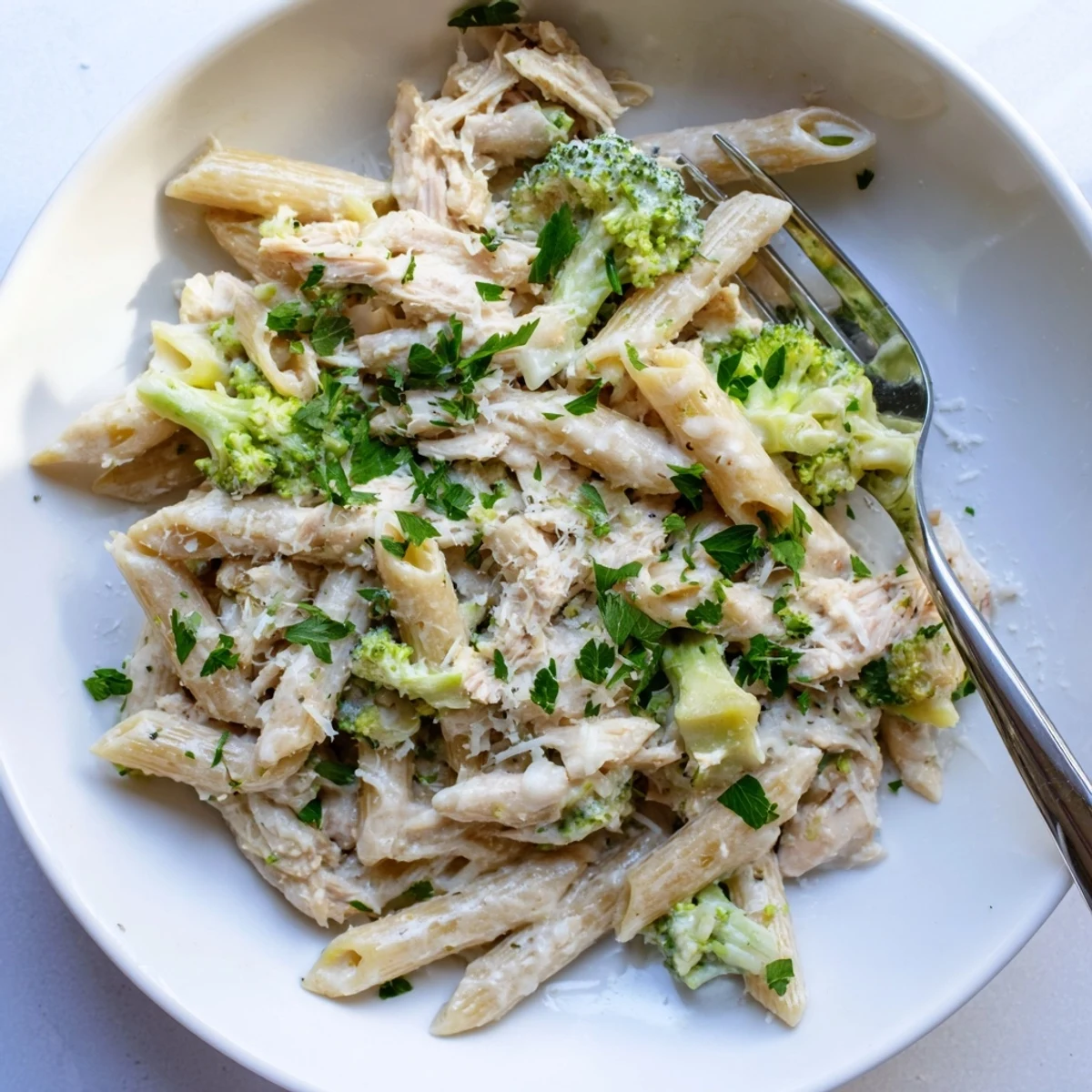 Rotisserie chicken broccoli pasta dinner featuring tender shredded chicken and crisp green florets