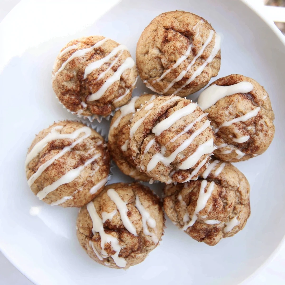 Fluffy high protein muffins featuring warm cinnamon swirls topped with powdered sugar icing