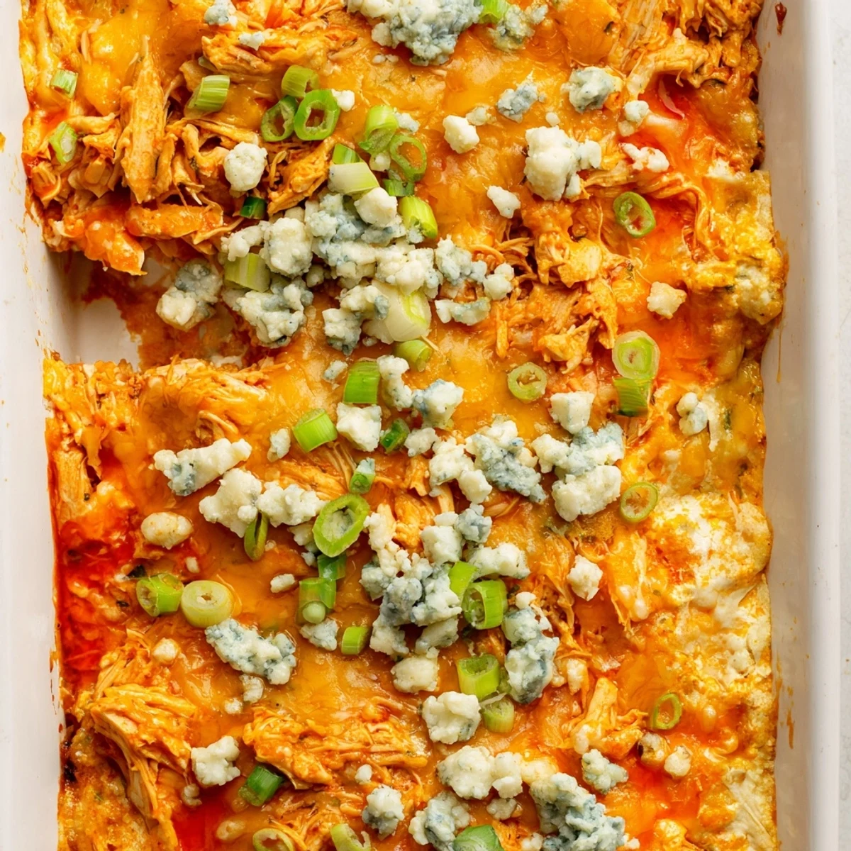 Hearty buffalo chicken cheese bake bubbling in a baking dish with crispy golden cheese topping