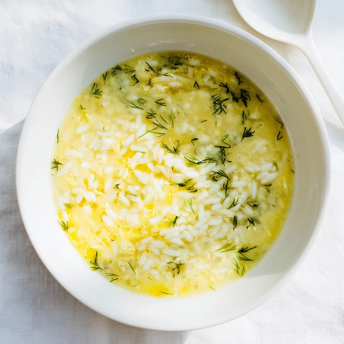Golden Greek Avgolemono soup featuring silky egg-lemon broth with fluffy white rice