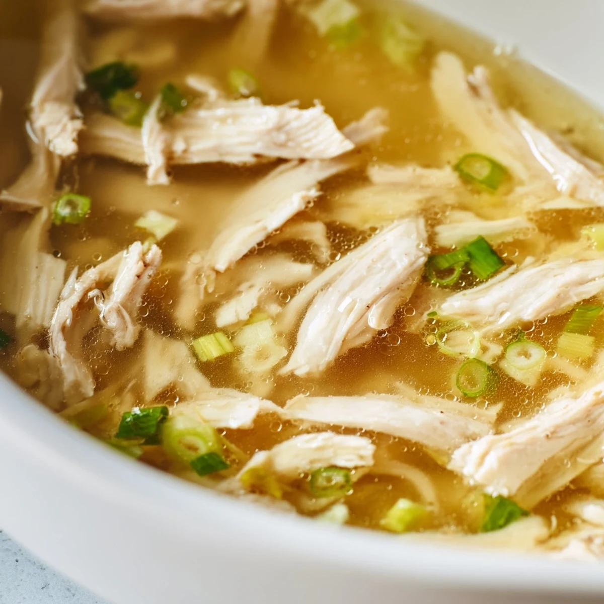 Steaming bowl of Dakgomtang Korean chicken soup topped with fresh green onions and served hot