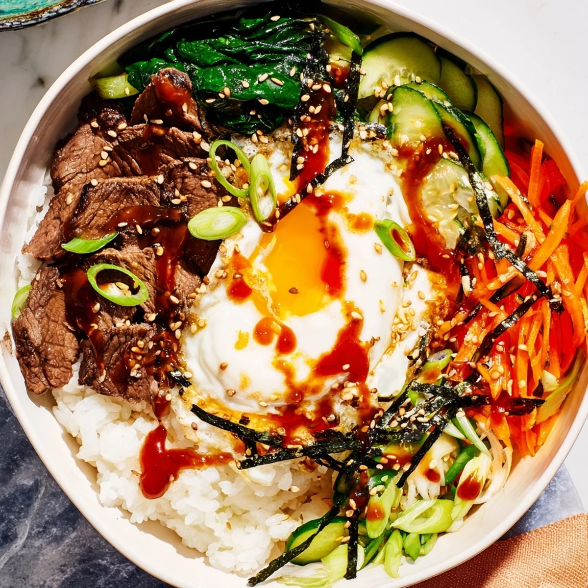 Colorful Korean-Inspired Breakfast Bowl drizzled with spicy gochujang sauce and topped with a runny fried egg