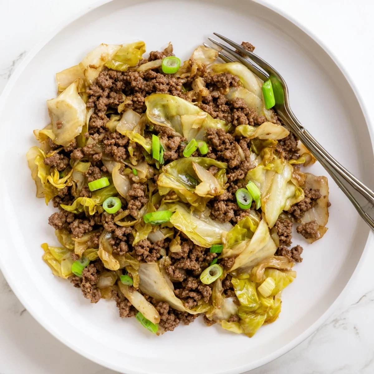 Steamy bowl of low carb Mongolian ground beef and cabbage with caramelized vegetables and aromatic ginger