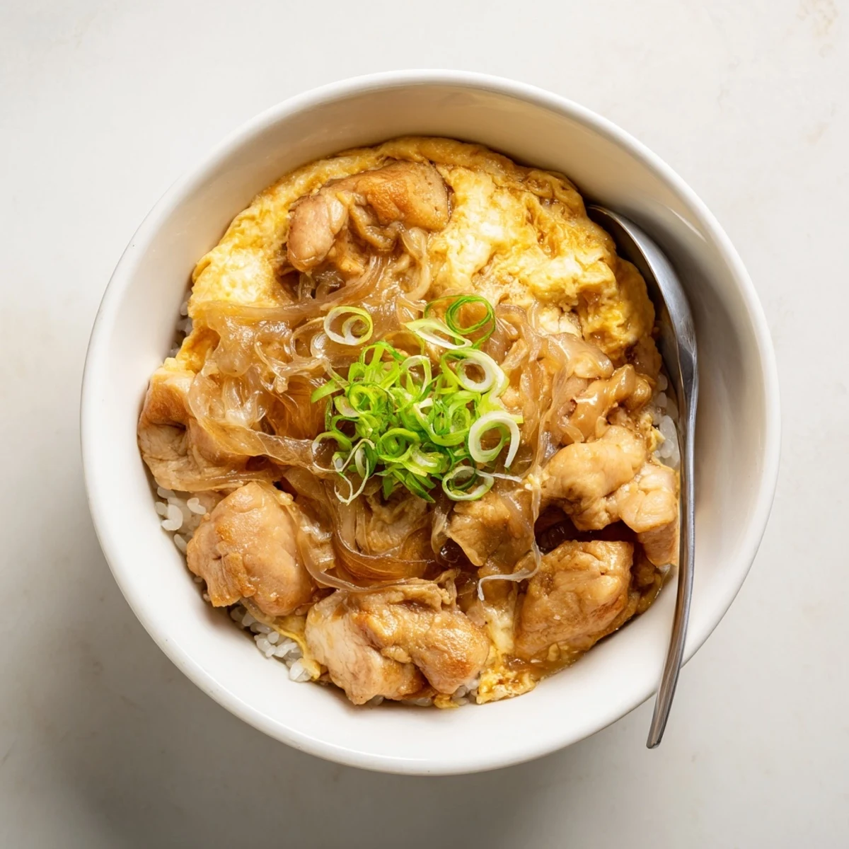 Golden Oyakodon served hot with caramelized onions, juicy chicken pieces, and silky egg topping