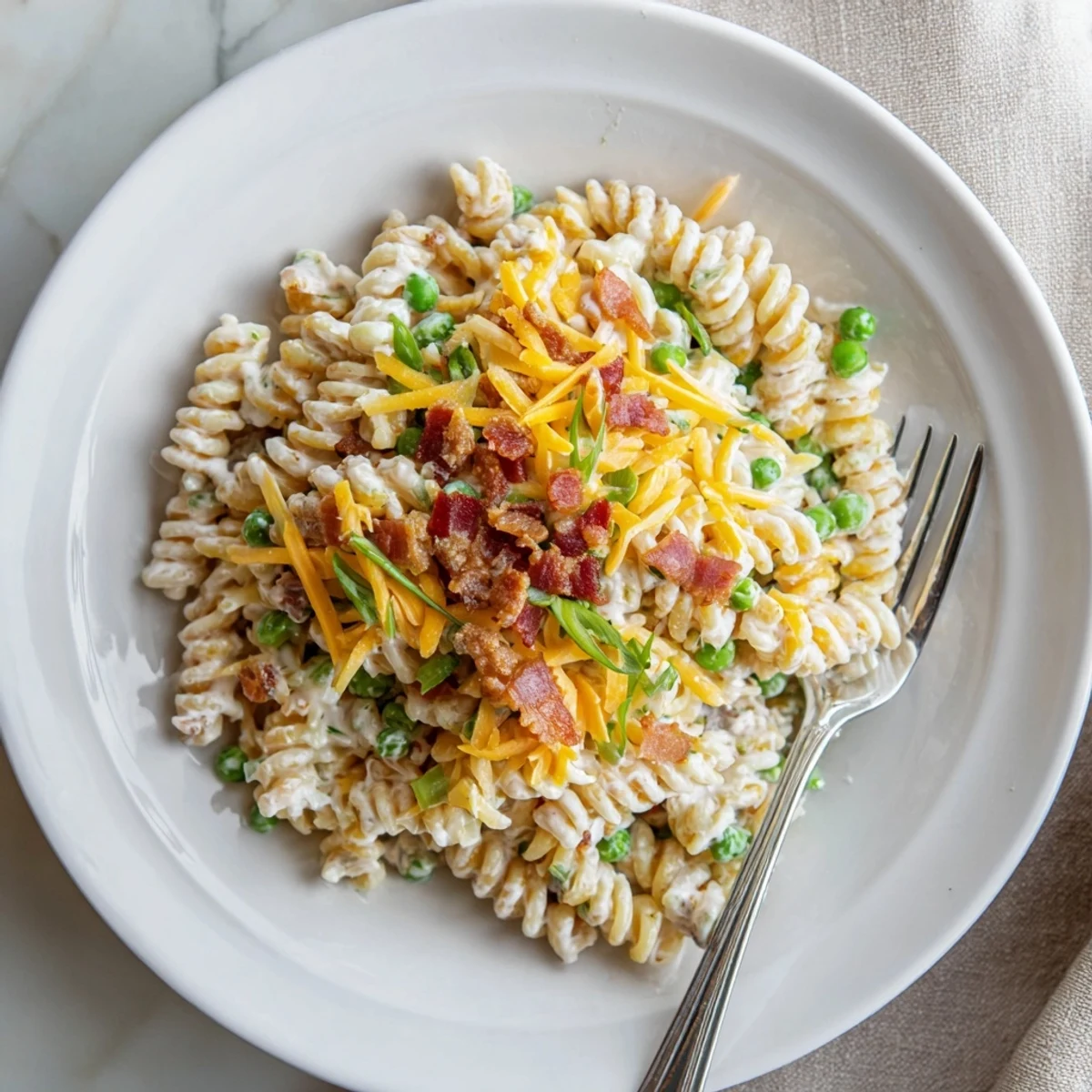 Creamy crack pasta salad loaded with crispy bacon and sharp cheddar cheese in a serving bowl
