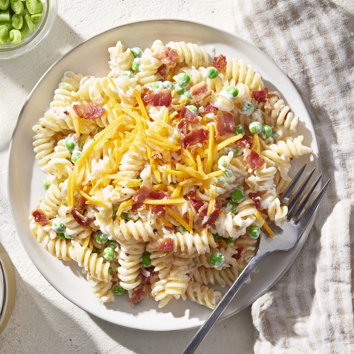 Cold ranch pasta salad featuring rotini noodles, green onions, and crumbled bacon for summer cookouts