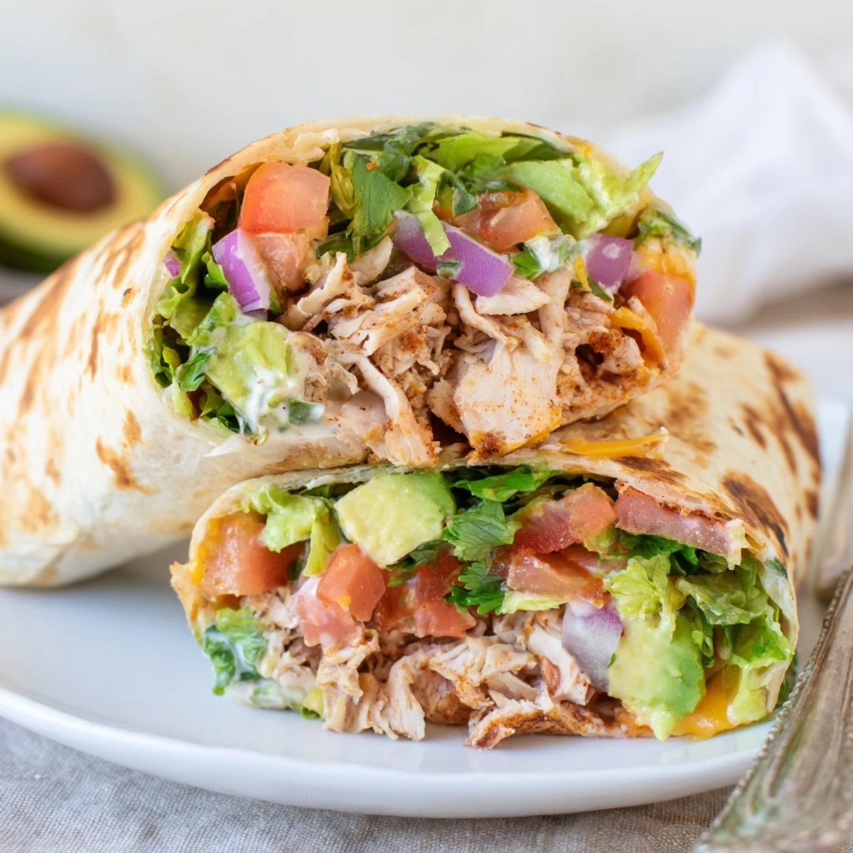 Family style Chicken Avocado Ranch Burritos arranged on platter, crisp lettuce and tomato