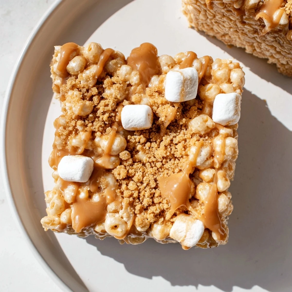 Golden Biscoff Rice Krispie Treats cut into squares next to coffee