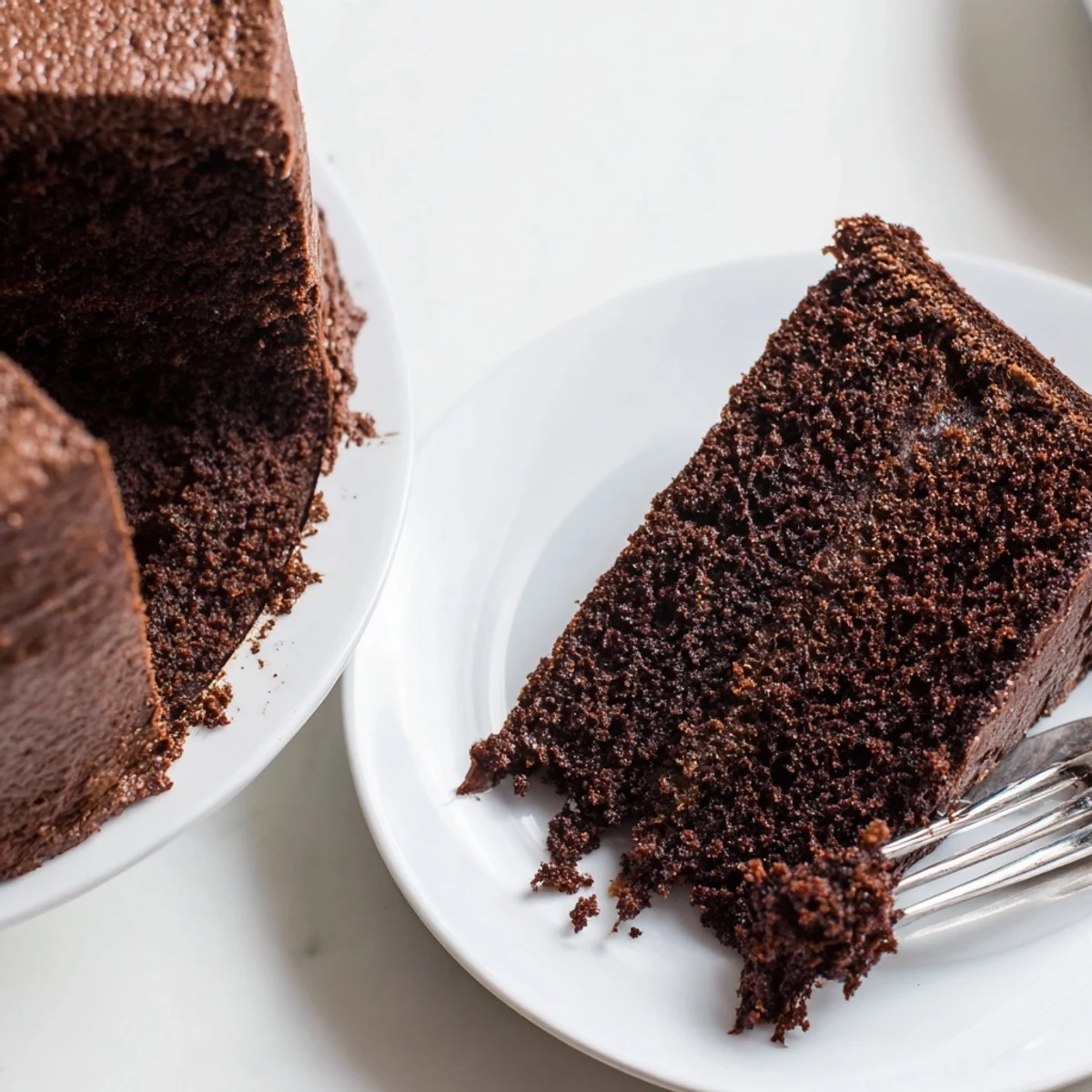 Moist chocolate cake with mayonnaise displaying a rich, tender crumb topped with creamy chocolate frosting