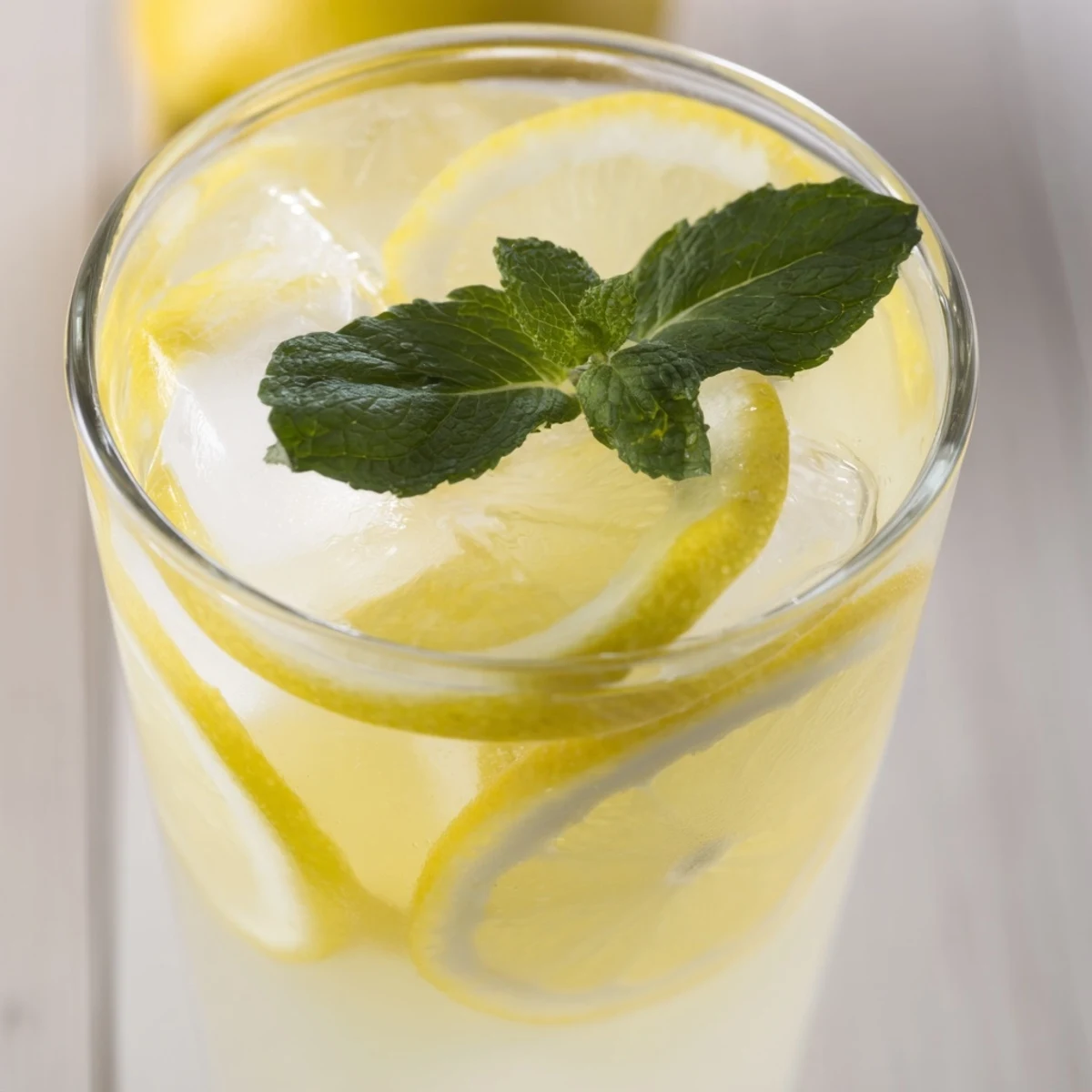 Pitcher of classic lemonade with lemon wheels and ice cubes ready for summer serving