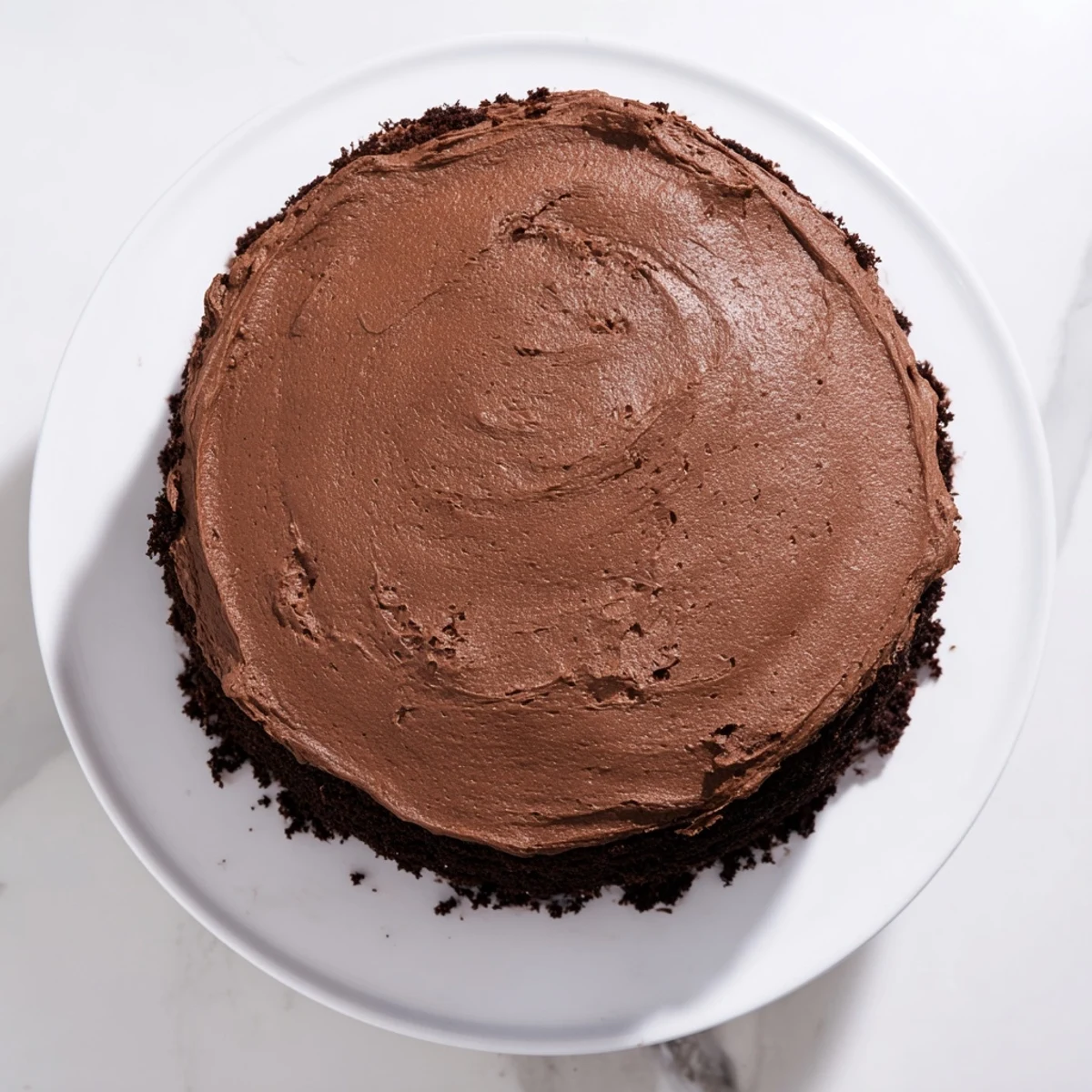 Decadent slice of Matildas Chocolate Cake with creamy chocolate frosting on a white serving plate