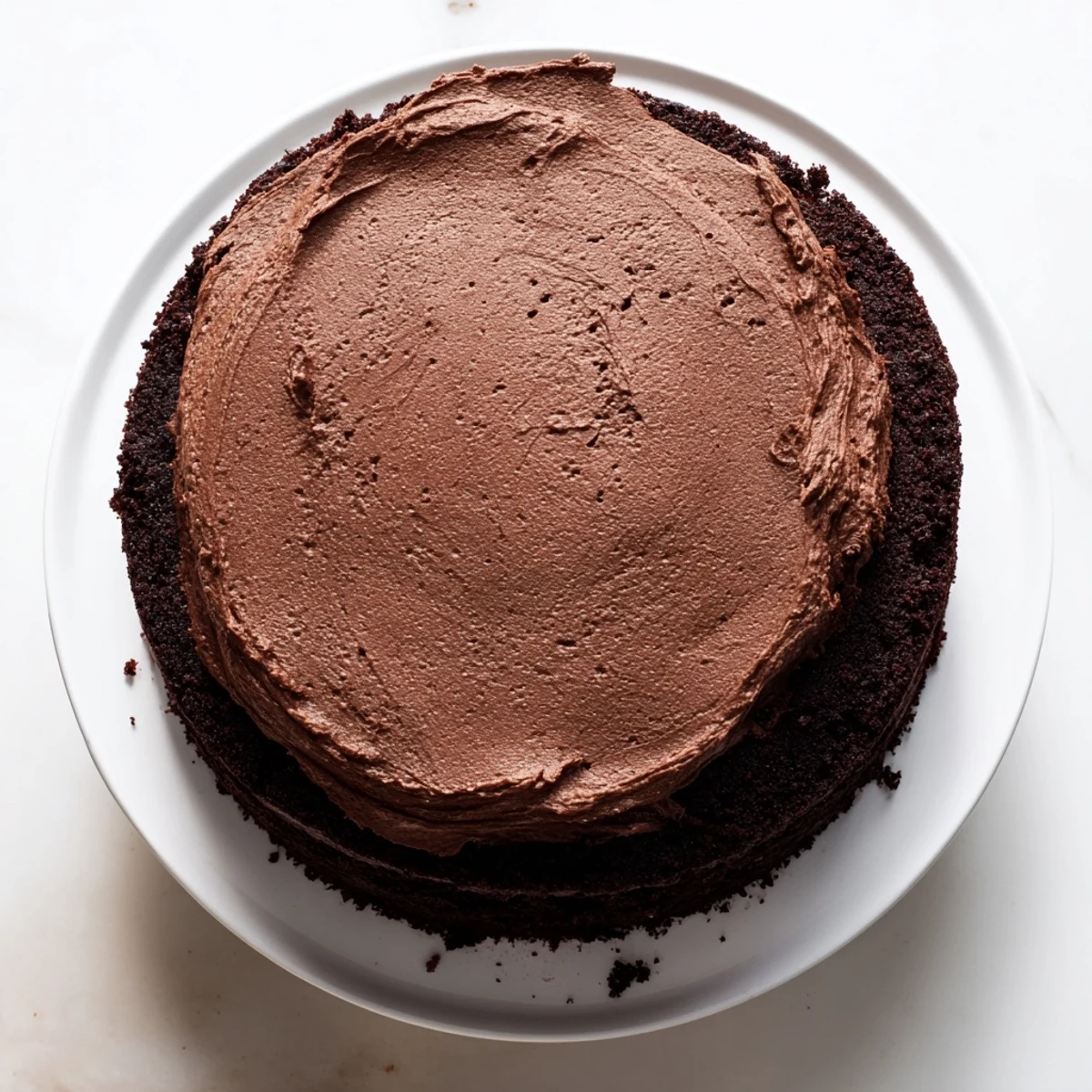 Moist Matildas Chocolate Cake layered with buttercream frosting dusted with cocoa powder