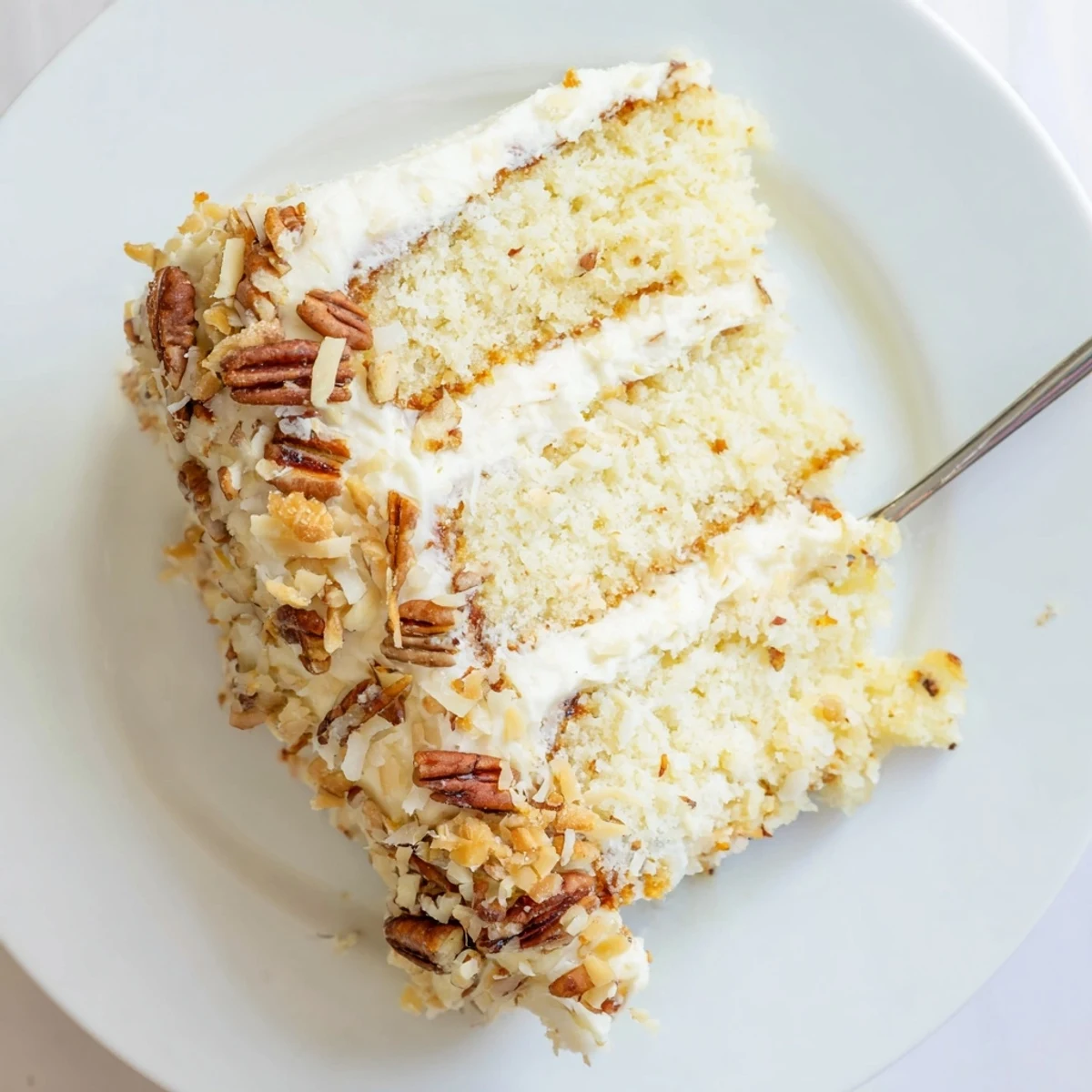 Homemade Quick Italian Cream Cake with shredded coconut and chopped pecans in cream cheese frosting