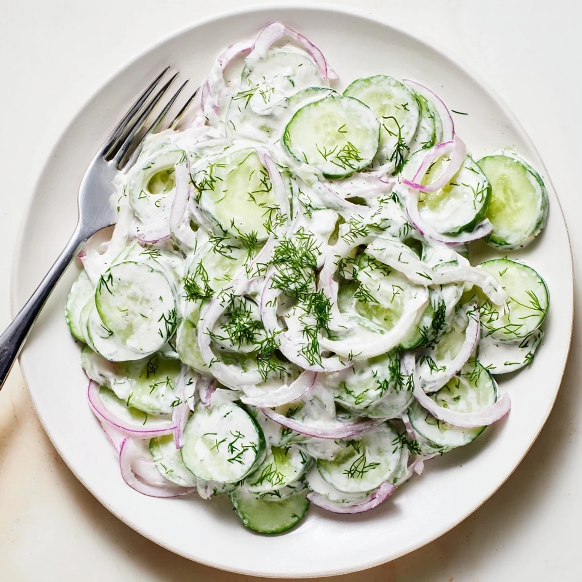 Crisp cucumber dill salad topped with fresh herbs and light tangy dressing for summer