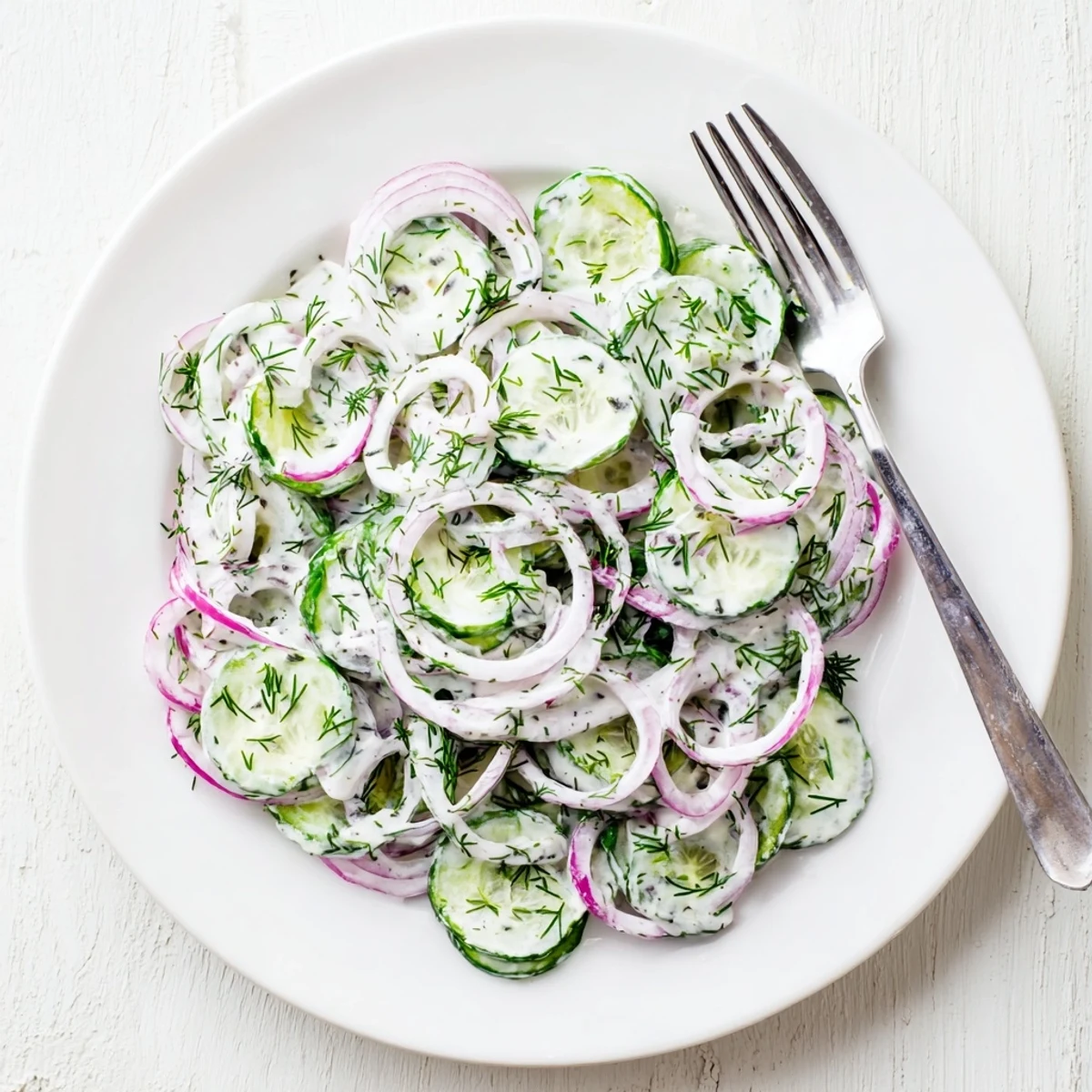 Creamy cucumber dill salad served chilled with red onion and fresh dill garnish