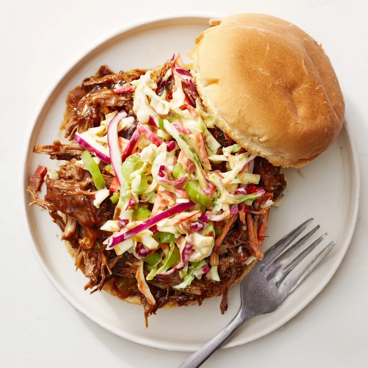 Homemade BBQ beef sandwiches featuring slow-roasted meat topped with crisp tangy cabbage slaw