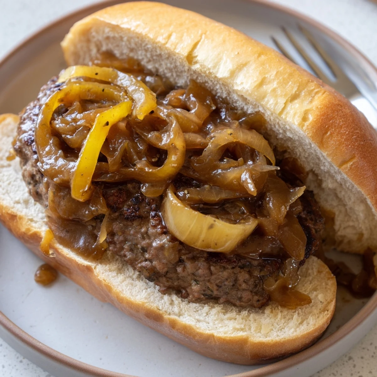 Golden seared hamburger steak sandwiches nestled in soft buns under a thick savory onion gravy