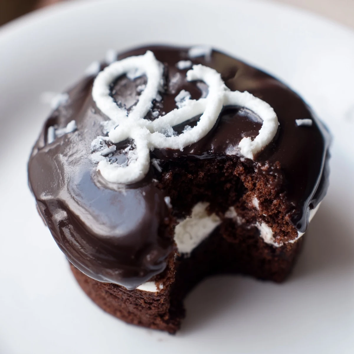 Rich Homemade Hostess Cupcakes topped with shiny glaze dusted with cocoa powder