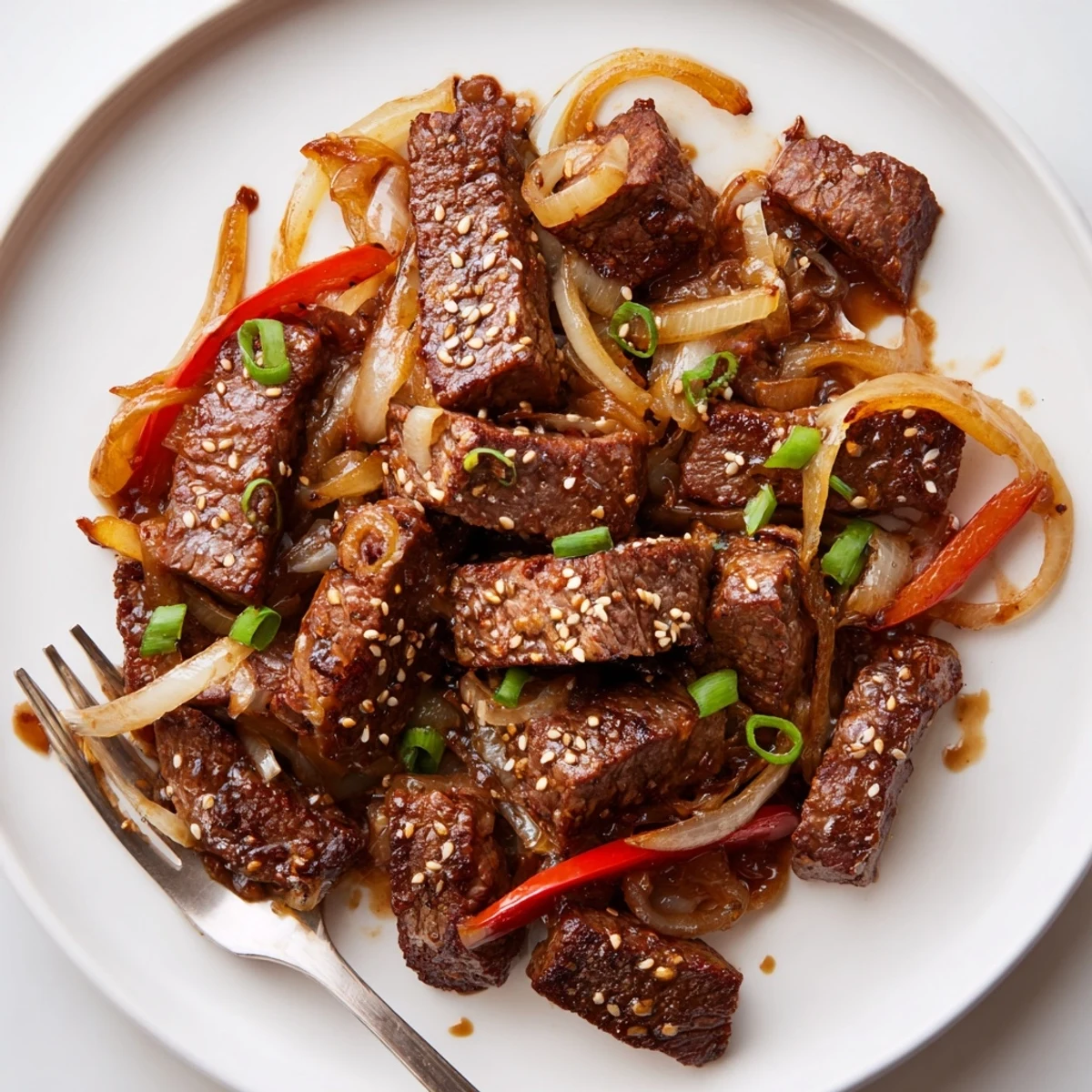 Tender Asian inspired cube steak glazed in rich soy sauce with colorful bell peppers and green onion garnish
