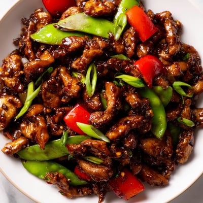 Glossy stir fried Chinese garlic chicken coated in savory garlic sauce over jasmine rice